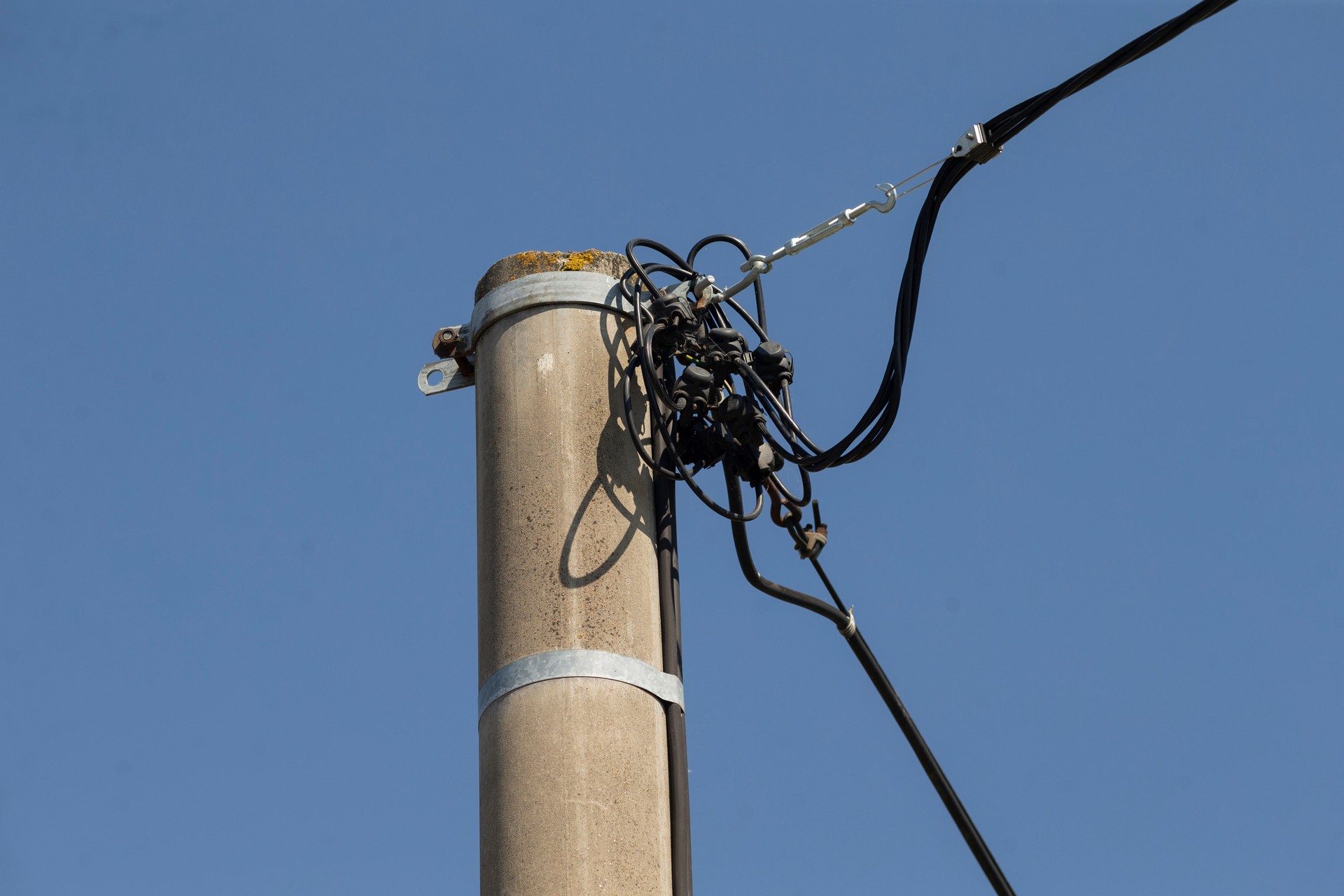 Équipement de télécommunication installé sur un poteau électrique contre le ciel bleu